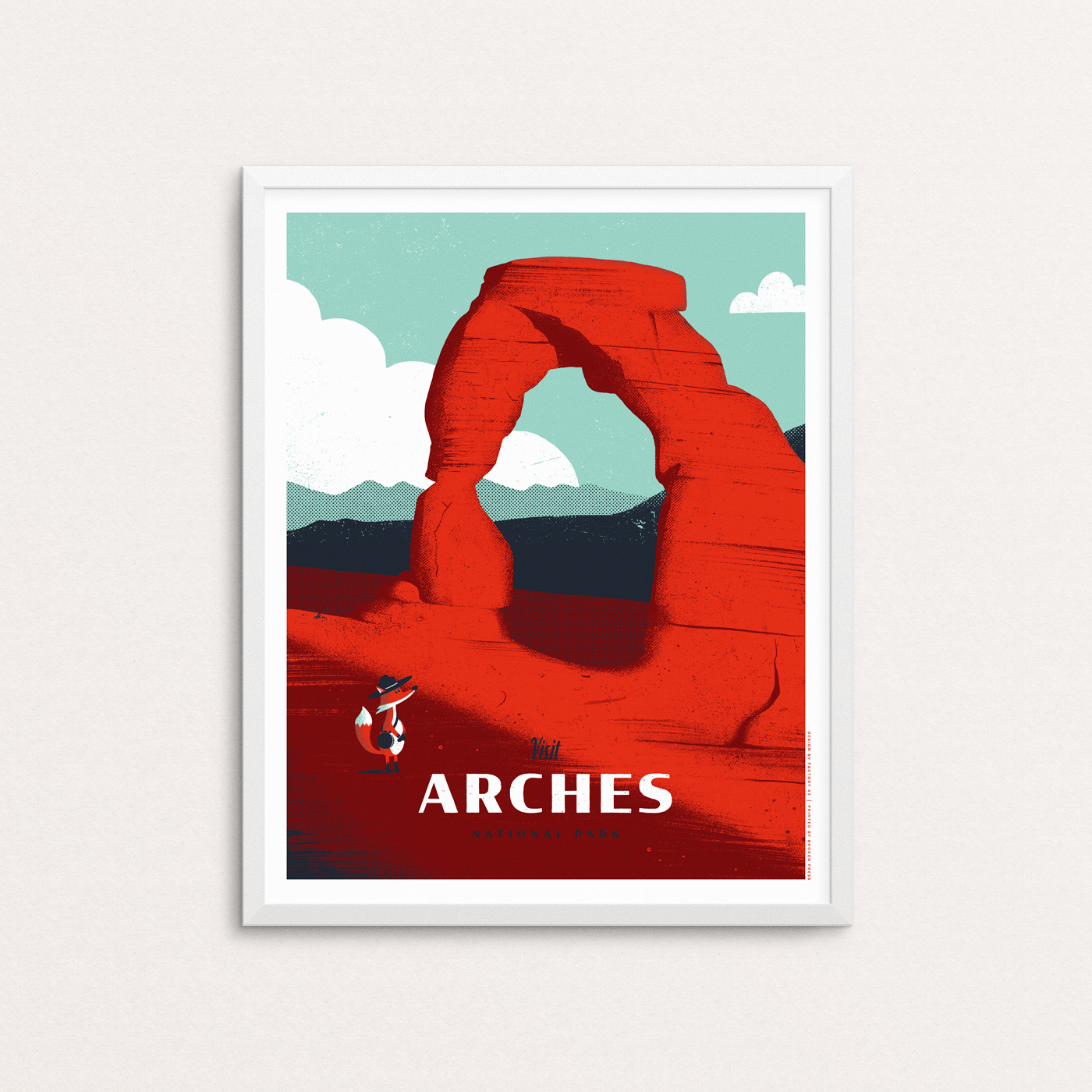 Arches National Park poster featuring a fox with a hat and canteen admiring red rocks of Delicate Arch in Utah. The print is show in a white frame.